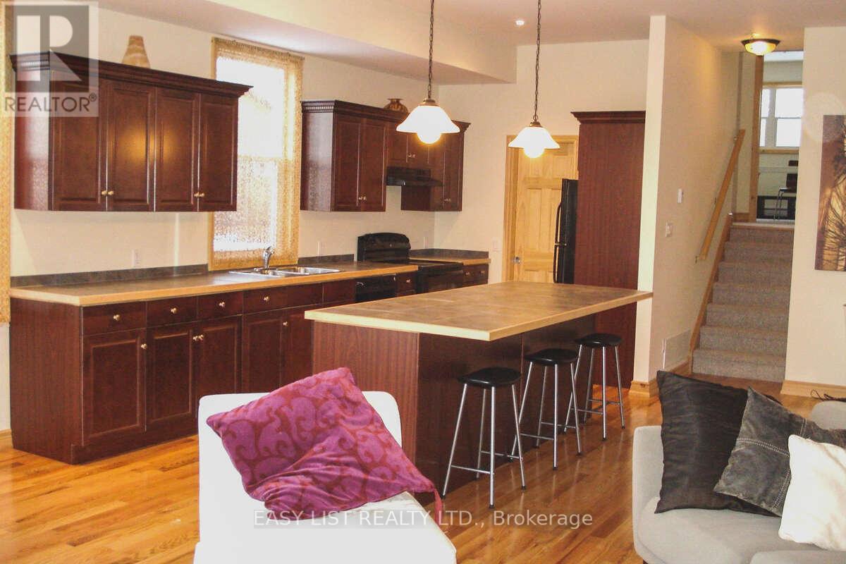 A kitchen with wooden cabinets and a bar stool.