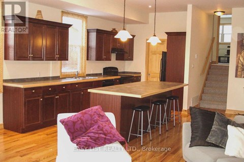 A kitchen with wooden cabinets and a bar stool.