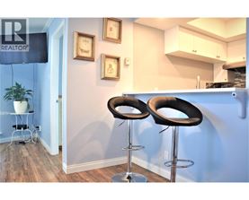 Two black bar stools in front of a blue wall.