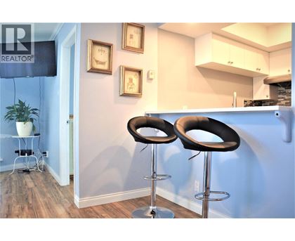 Two black bar stools in front of a blue wall.