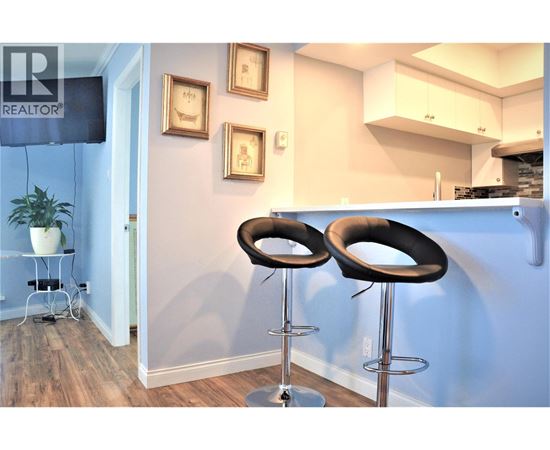 Two black bar stools in front of a blue wall.