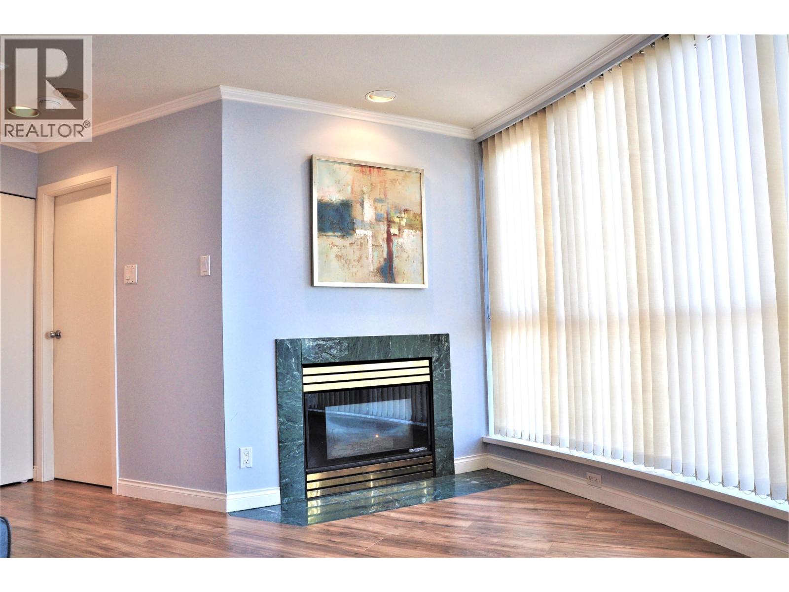 A living room with a fireplace and a painting on the wall.