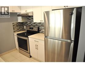A modern kitchen with a stainless steel refrigerator and oven.