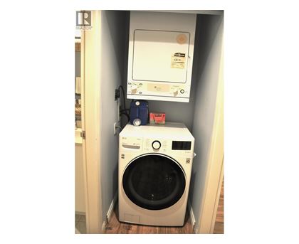A washing machine is sitting in a small space.