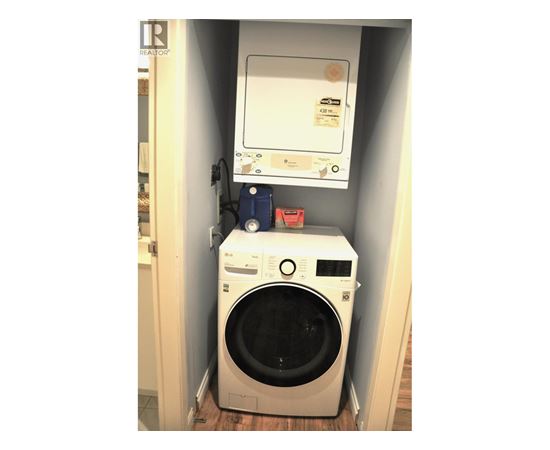 A washing machine is sitting in a small space.