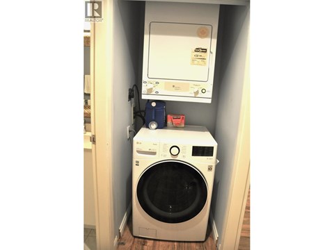 A washing machine is sitting in a small space.