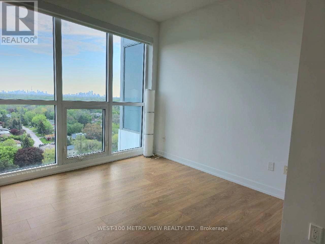 A room with a view of the city through large windows.