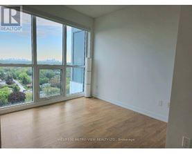 A room with a view of the city through large windows.