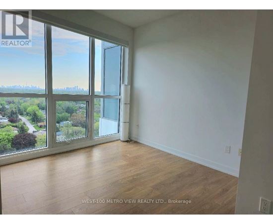 A room with a view of the city through large windows.
