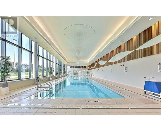 A large indoor swimming pool with a glass bottom.