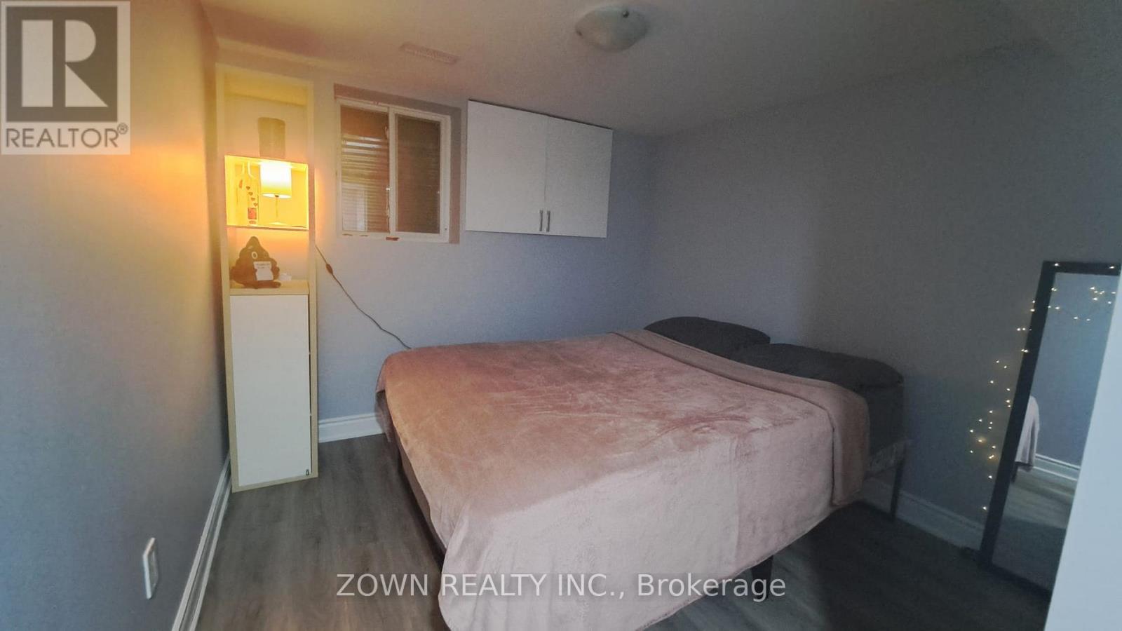 A bedroom with a bed, dresser, and mirror.