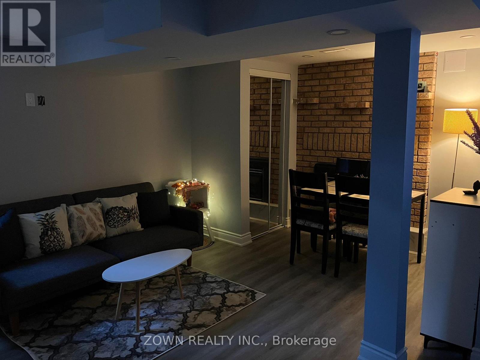 A living room with a couch, chairs, and a dining table.