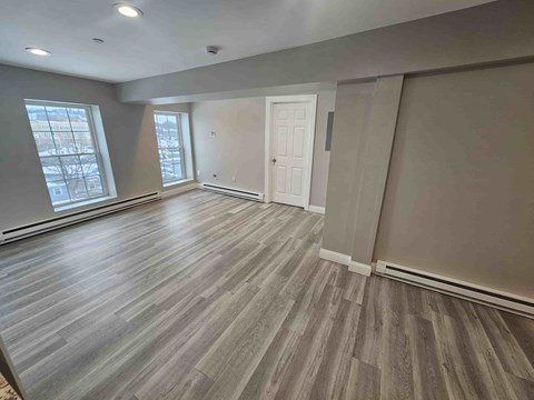 A room with wooden flooring and a white door.