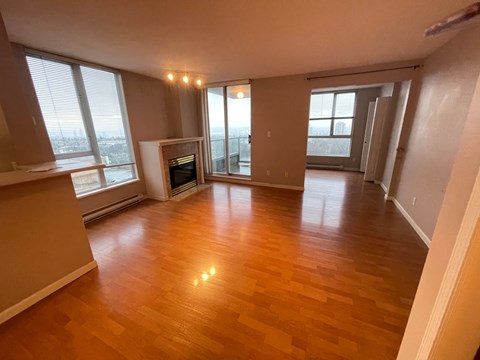 A spacious living room with hardwood floors and a fireplace.