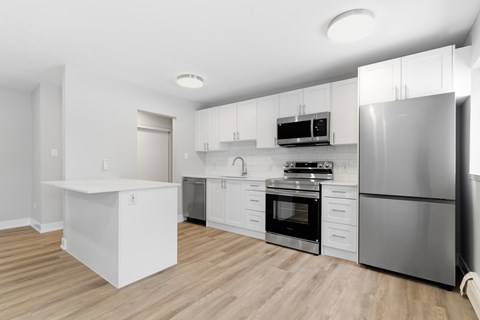A modern kitchen with stainless steel appliances and white cabinetry.
