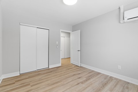 A room with a white door and a white closet.