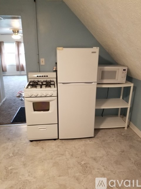 A white stove and refrigerator in a kitchen.