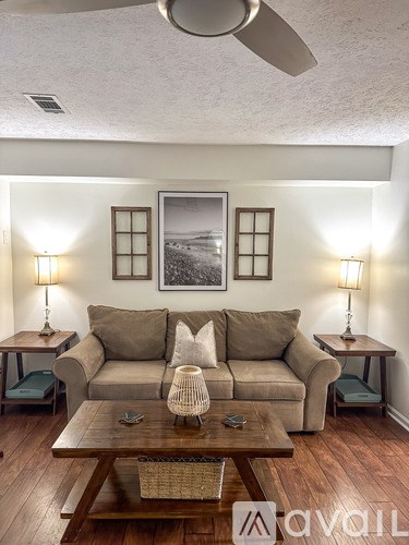 A living room with a couch, two lamps, and a painting on the wall.