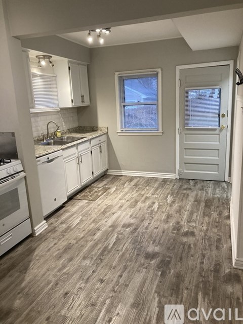 A kitchen with white appliances and cabinets.