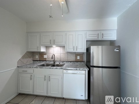 A kitchen with white cabinets and a stainless steel refrigerator.