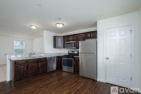 A kitchen with dark wood cabinets and stainless steel appliances.