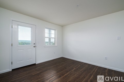 A room with a white door and a window with white blinds.
