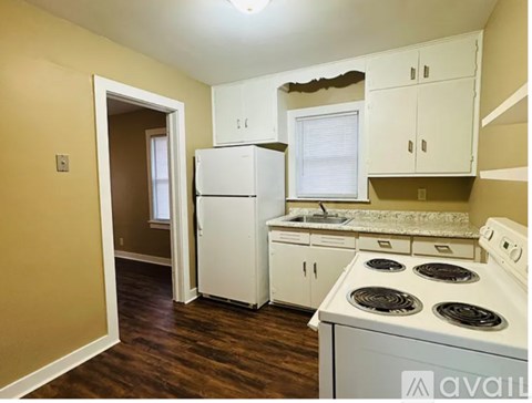 A kitchen with white appliances and cabinets.
