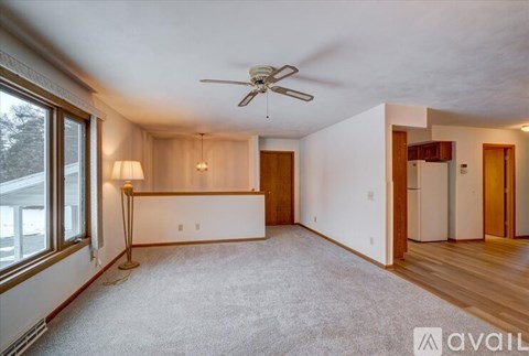 A spacious room with a ceiling fan and a carpeted floor.