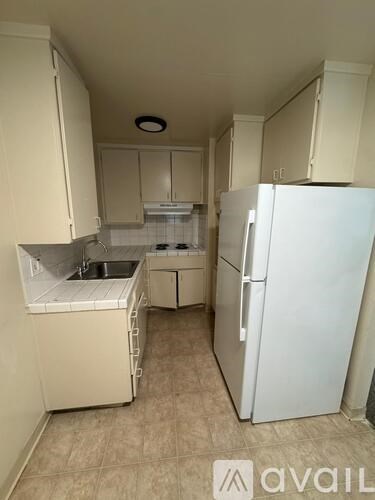 A small kitchen with a sink, stove, and refrigerator.