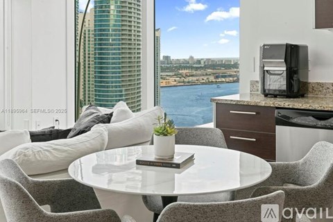 A modern dining area with a table set for two and a view of the city.