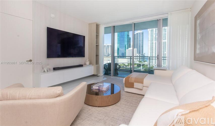 A living room with a white couch, a coffee table, and a flat screen TV.