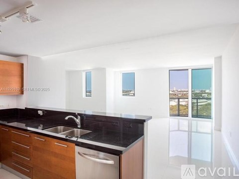 A kitchen with a sink, a window and a counter.