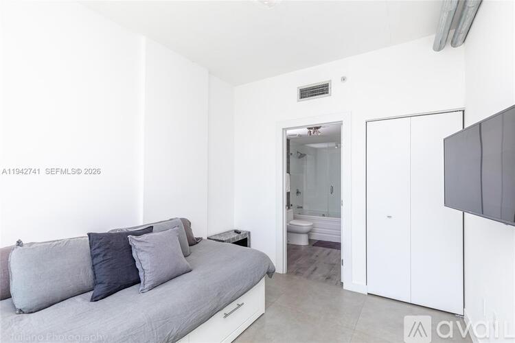 A bedroom with a bed, nightstand, and wardrobe.