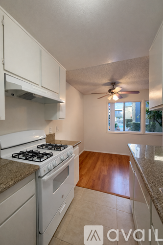 A kitchen with a white stove and cabinets.