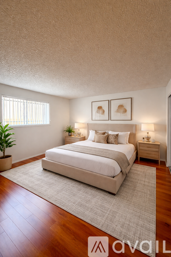 A bedroom with a large bed and two nightstands with lamps.