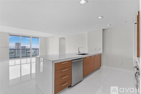 A modern kitchen with a large island and stainless steel appliances.
