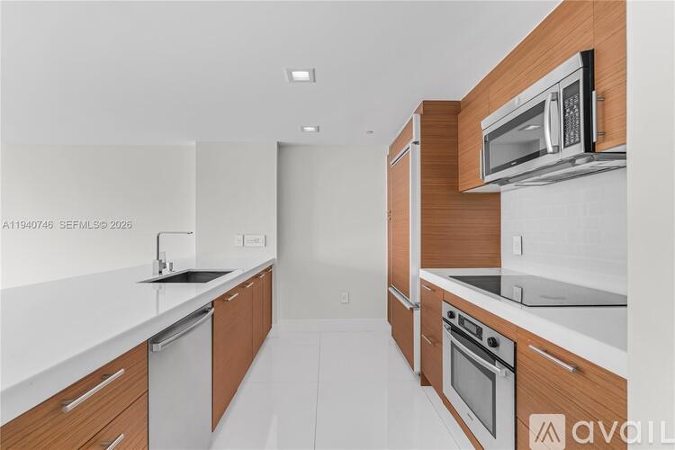 A modern kitchen with wooden cabinets and stainless steel appliances.