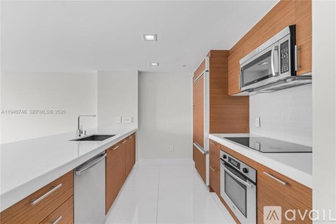 A modern kitchen with wooden cabinets and stainless steel appliances.