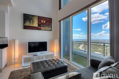 A living room with a television, a couch, and a painting on the wall.