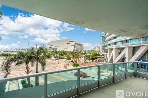 A balcony overlooks a parking lot and palm trees.
