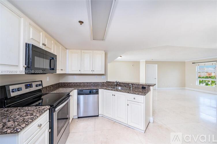 A kitchen with granite countertops and white cabinets.