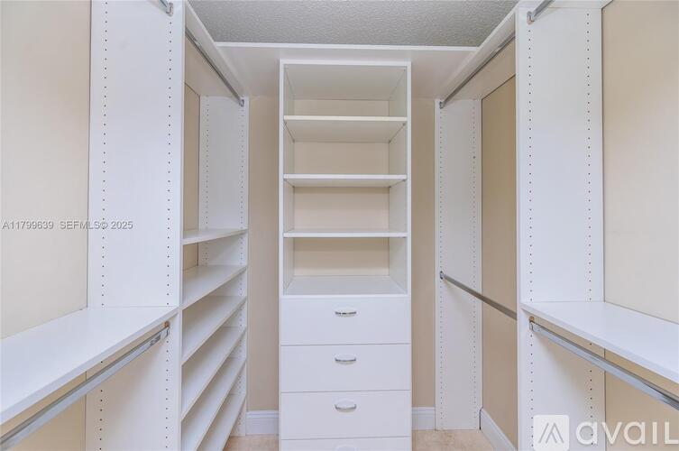 A white walk-in closet with shelves and drawers.