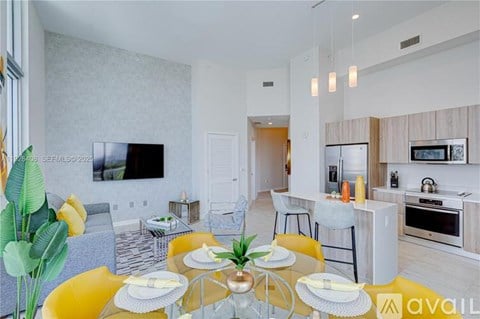 A modern dining room with a glass table and yellow chairs.