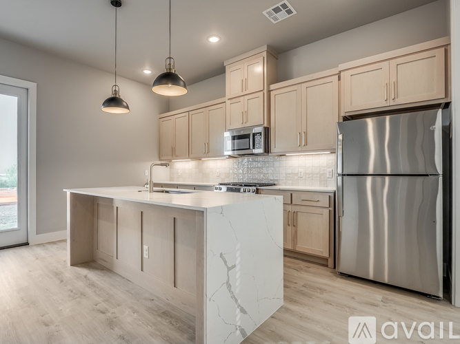 A modern kitchen with a stainless steel refrigerator and wooden cabinets.