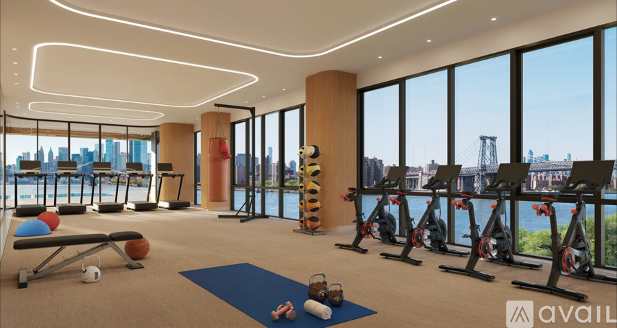 A gym with exercise equipment and a view of the city skyline.