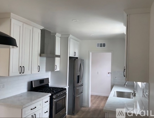 A kitchen with white cabinets and a black stove top oven.