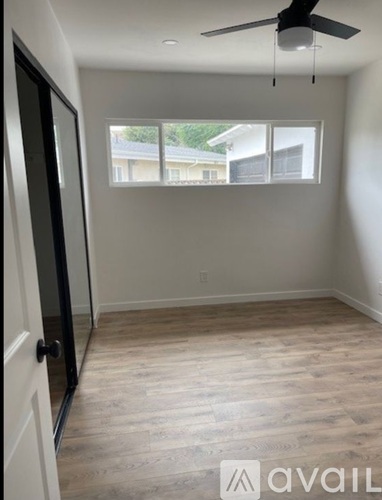 A room with a ceiling fan and a door leading to a balcony.