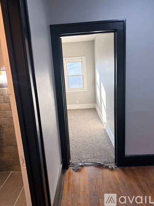A black door with a mirror on the side is open.