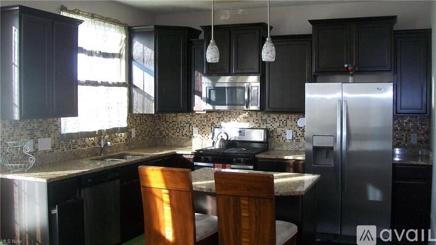 A kitchen with black cabinets and a granite countertop.