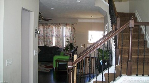 A living room with a couch and a staircase.